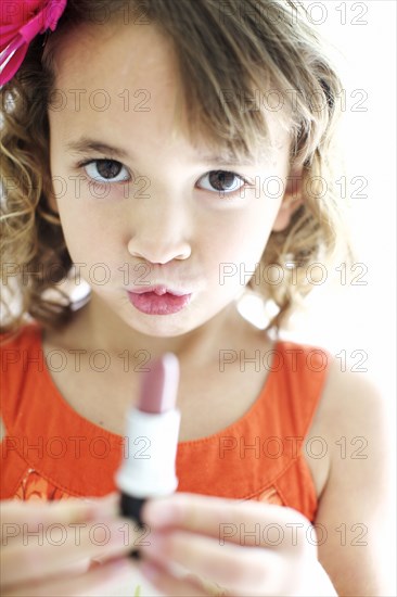 Mixed race girl playing with lipstick