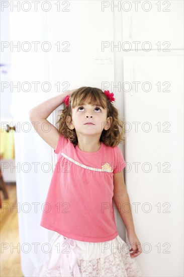 Mixed race girl measuring her height