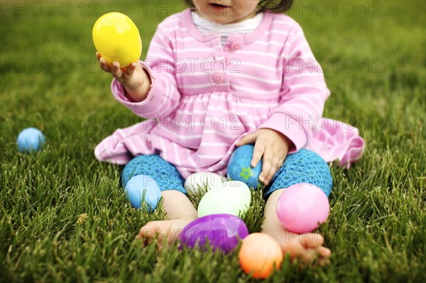 Mixed race girl playing with Easter eggs