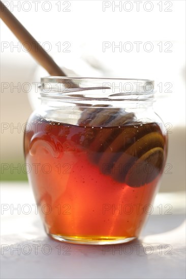 Close up of honey and wooden dipper