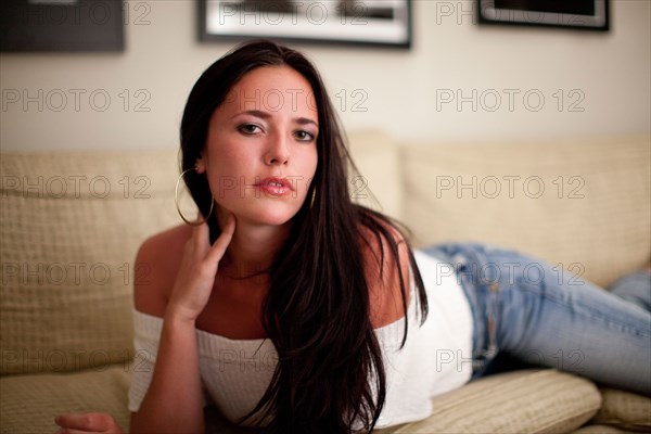 Alluring Caucasian woman laying on sofa