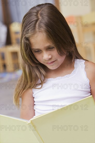 Hispanic girl reading book