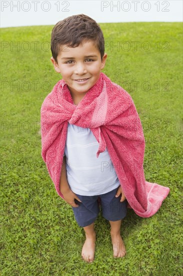 Hispanic boy wearing towel cape