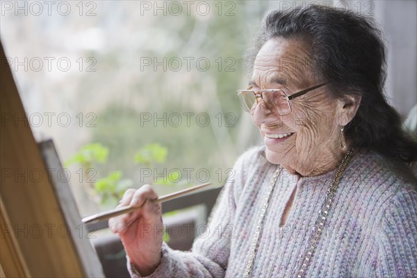 Senior Hispanic woman painting