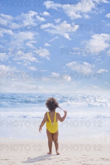 Hispanic girl standing on beach