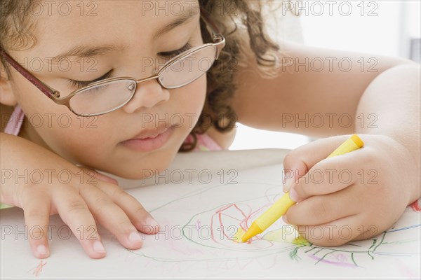 Hispanic girl coloring with crayon