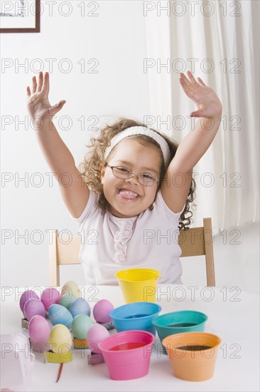 Hispanic girl decorating Easter eggs