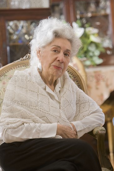 Senior Hispanic woman sitting in chair