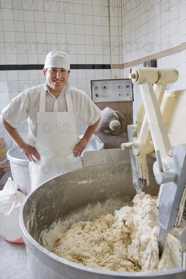 Hispanic baker mixing dough