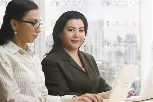 Businesswomen using laptops