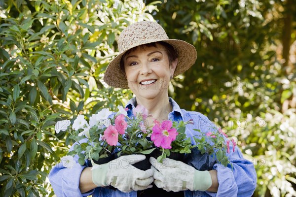 Hispanic woman in garden holding flowers