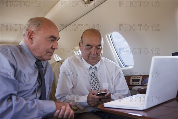 Hispanic businessmen working on private jet