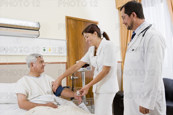 Doctor and nurse examining patient in hospital room