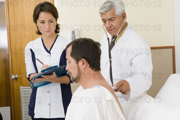 Doctor and nurse examining patient in hospital room