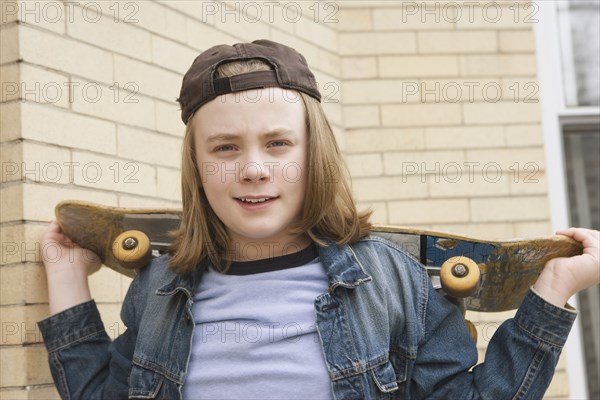 Caucasian boy standing with skateboard