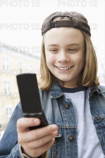 Caucasian boy text messaging on cell phone