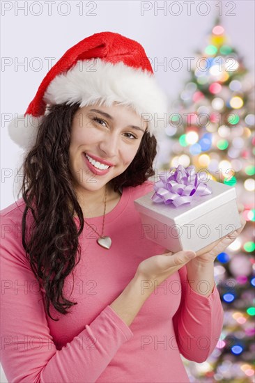 Mixed race woman holding Christmas gift