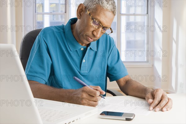 Mixed race man paying bills online