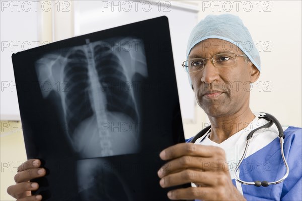 Mixed race surgeon looking at x-rays