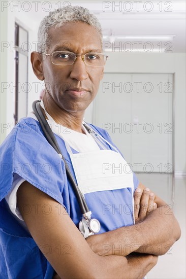 Mixed race surgeon with arms crossed