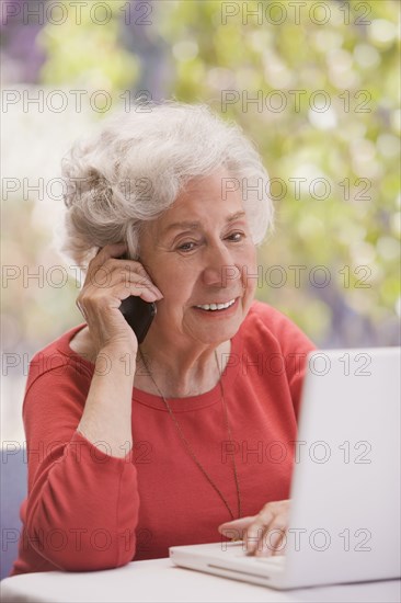 Chilean woman talking on cell phone and  using laptop
