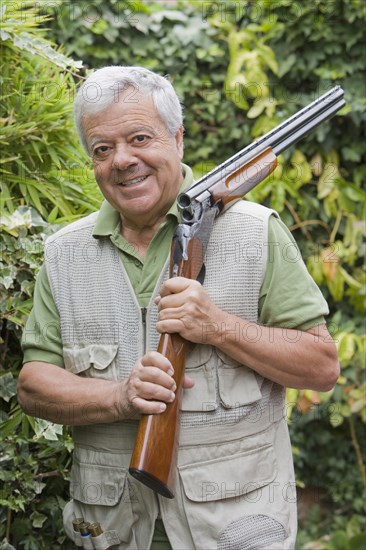 Senior Chilean man holding shotgun