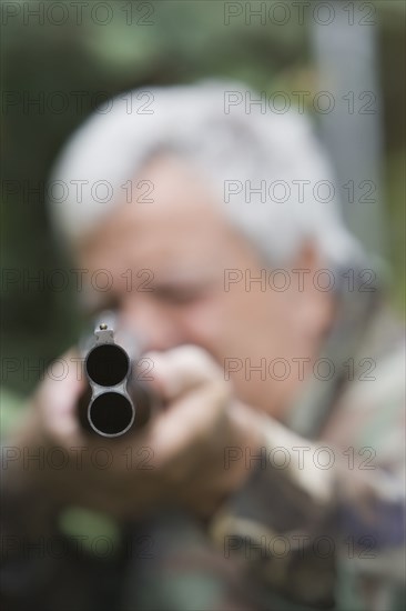 Senior Chilean man pointing shotgun