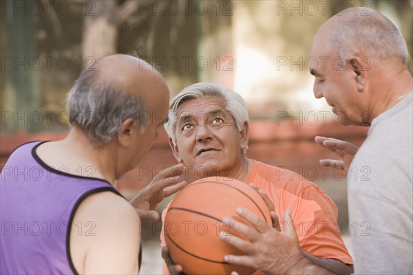Senior Chilean men playing basketball together