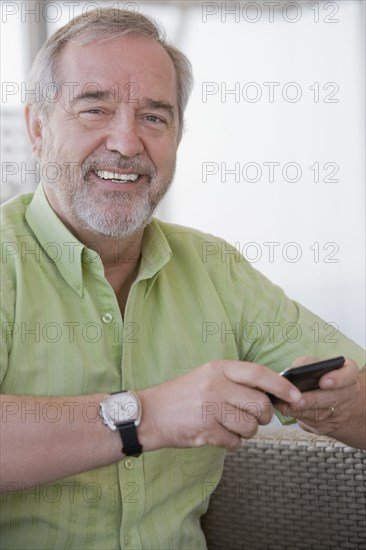 Senior Chilean man text messaging on cell phone