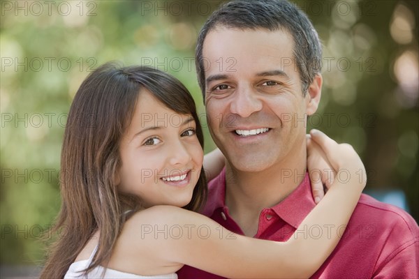 Hispanic daughter hugging father