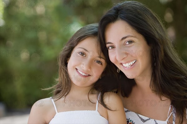 Smiling Hispanic mother and daughter