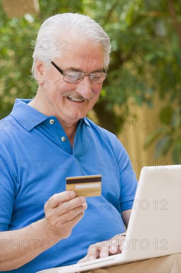 Senior Hispanic man shopping online with credit card