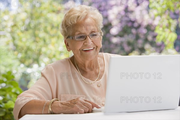 Senior Hispanic woman using laptop