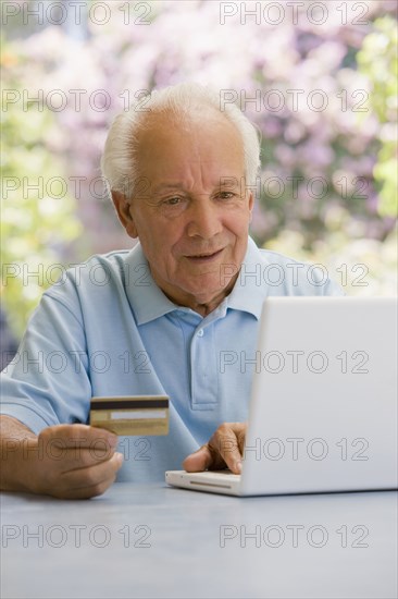 Senior Hispanic man shopping online with credit card