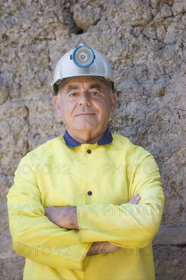 Hispanic miner in coat and hard-hat