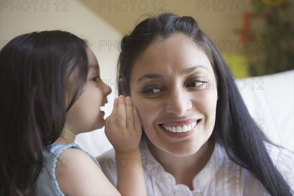 Hispanic girl whispering to mother