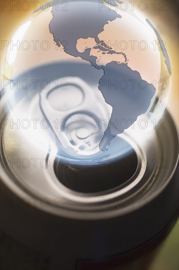 Transparent globe hovering over aluminum can