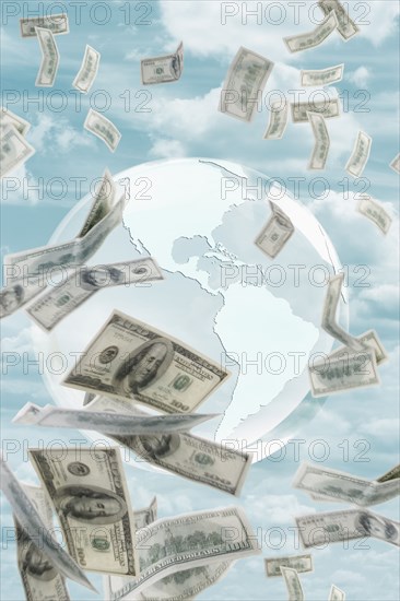 Globe and money floating in sky