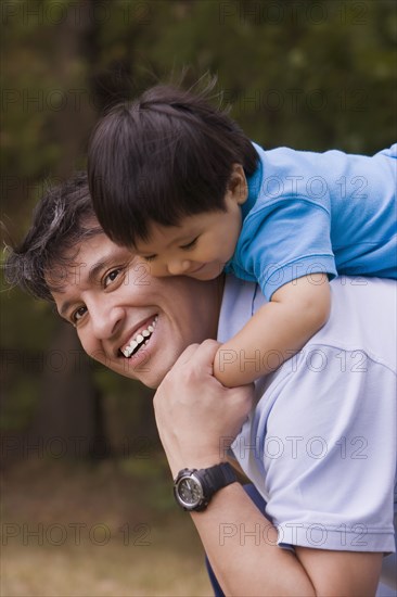 Smiling father giving piggyback to baby boy