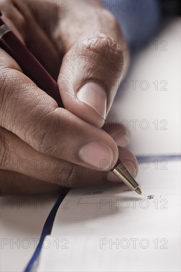 Mixed race man writing a check