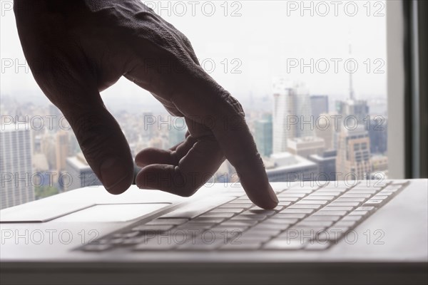 Mixed race man typing on laptop