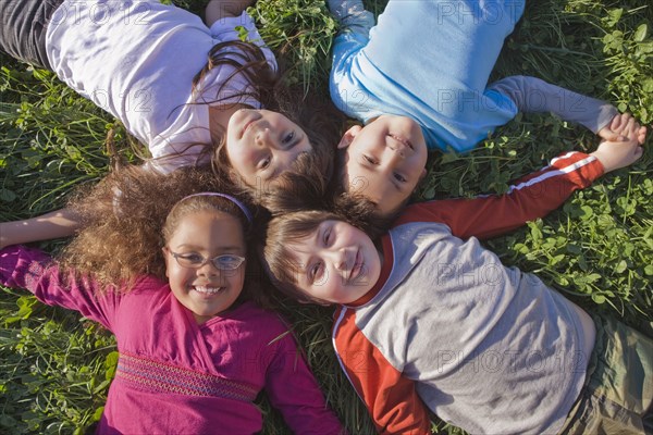 Hispanic children laying in grass together