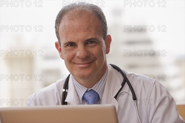 Smiling Chilean doctor with laptop
