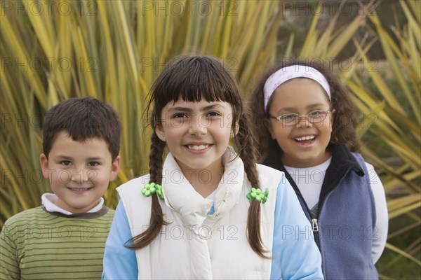 Smiling Hispanic children standing outdoors