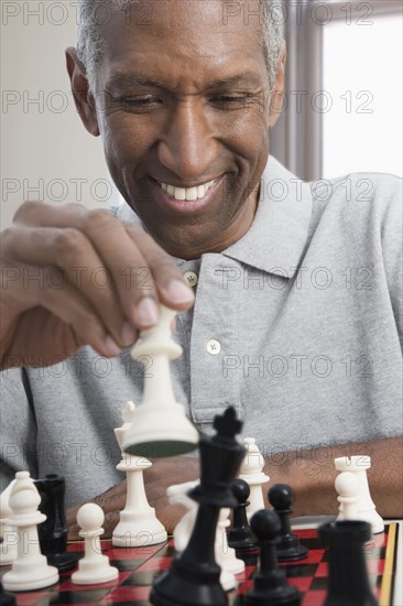 Smiling mixed race man playing chess