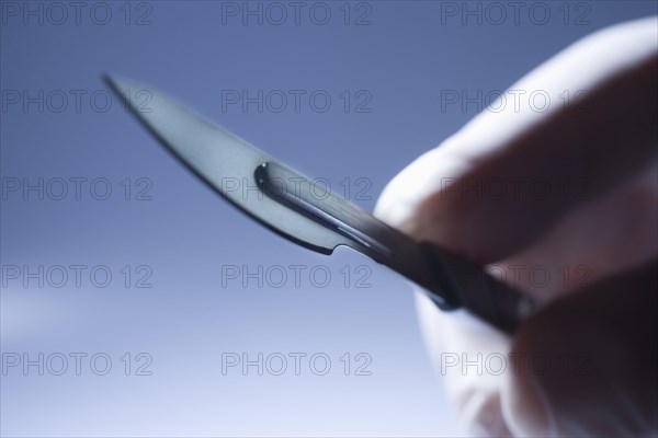 Close up of Hispanic doctor holding surgical equipment