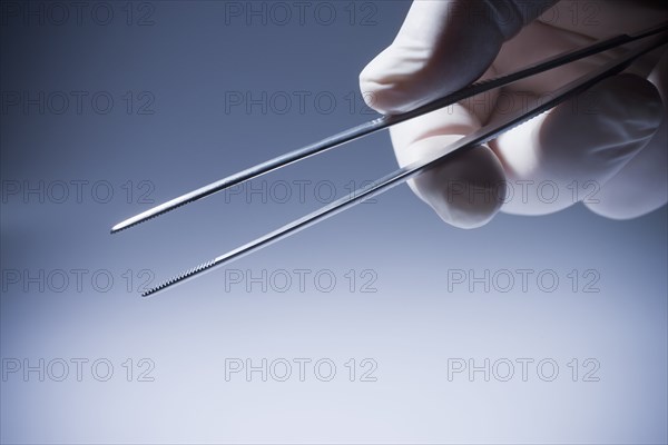 Close up of Hispanic doctor holding tweezers