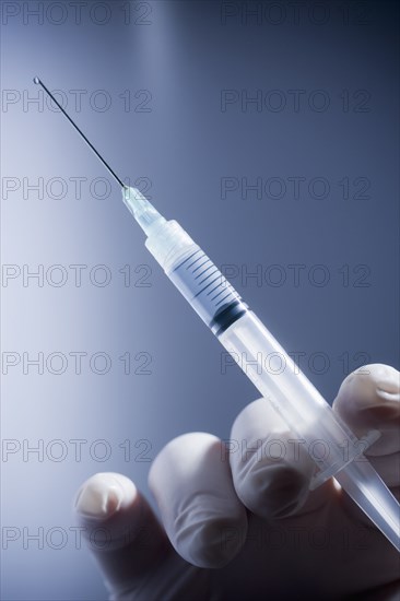 Close up of Hispanic doctor holding syringe