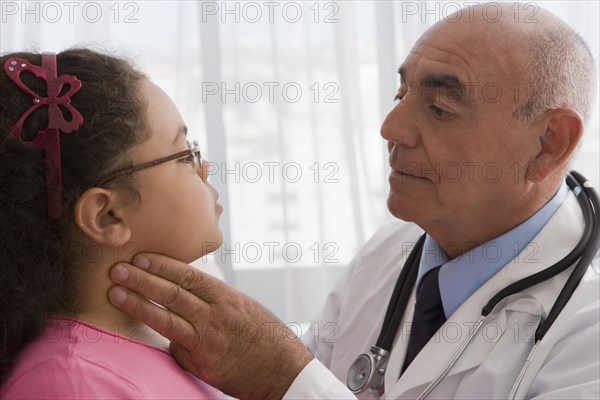 Hispanic doctor checking patient's throat