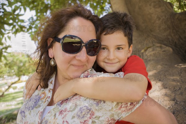 Hispanic mother carrying son piggyback